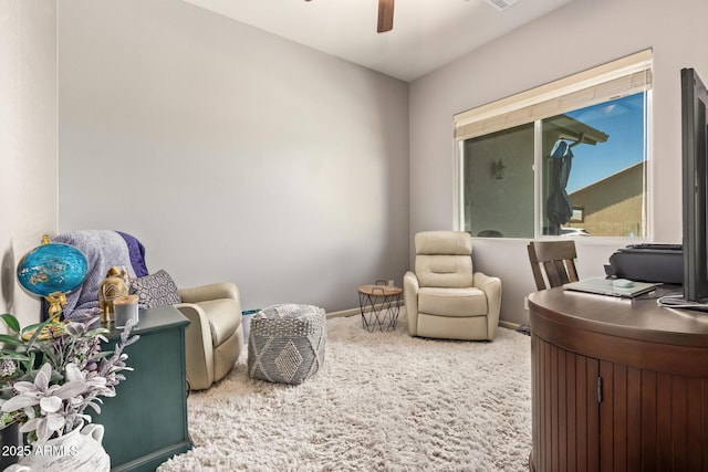 living area with carpet floors, a ceiling fan, and baseboards