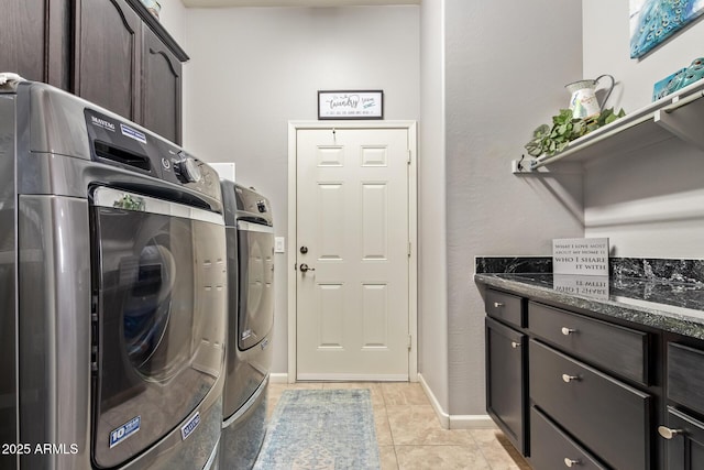 washroom with cabinet space, light tile patterned flooring, baseboards, and washer and clothes dryer