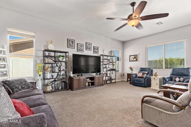 living area with a ceiling fan, carpet flooring, and visible vents