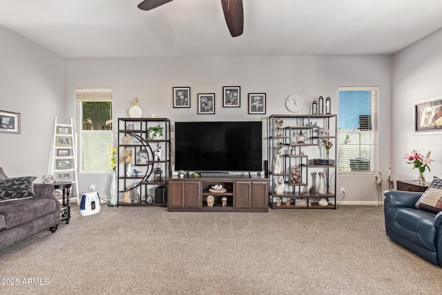 living area with a ceiling fan, plenty of natural light, and carpet