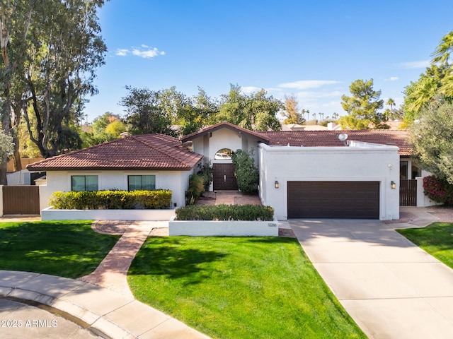 mediterranean / spanish house with a garage and a front lawn