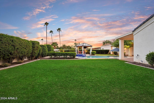 yard at dusk featuring a gazebo