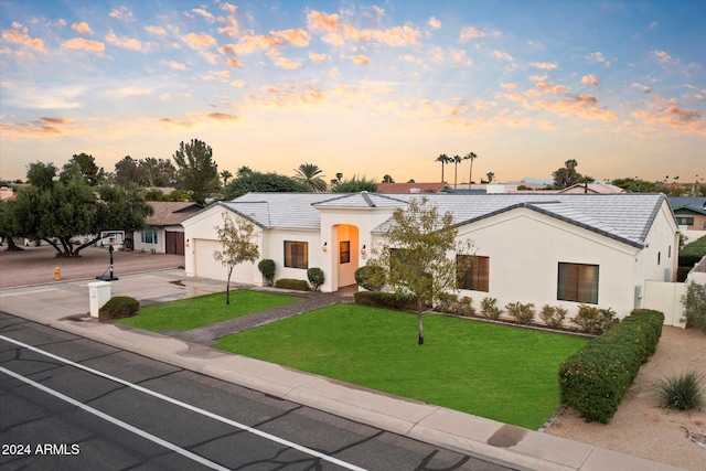 view of front of property featuring a lawn and a garage