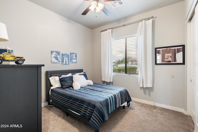 bedroom with ceiling fan, light carpet, and a closet