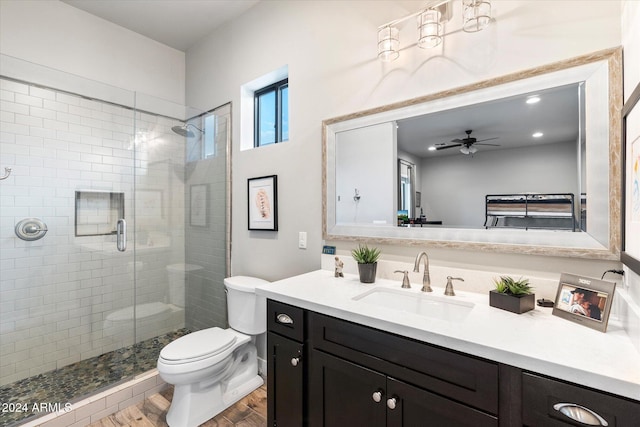 bathroom with vanity, a shower with door, ceiling fan, hardwood / wood-style floors, and toilet