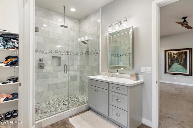 bathroom featuring hardwood / wood-style floors, ceiling fan, a shower with shower door, and vanity