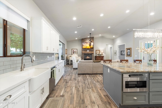 kitchen with gray cabinetry, white cabinetry, sink, hardwood / wood-style floors, and vaulted ceiling