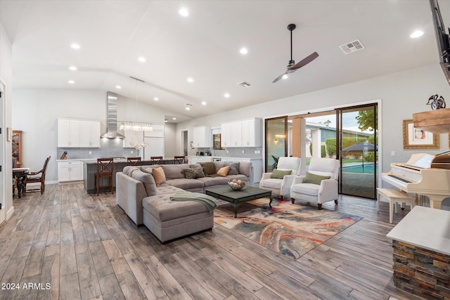 living room featuring ceiling fan, wood-type flooring, and lofted ceiling