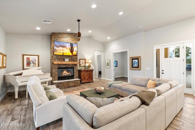 living room with a fireplace, light hardwood / wood-style floors, and high vaulted ceiling