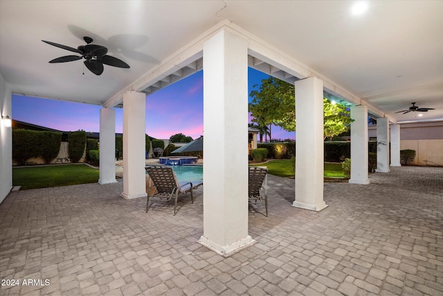 patio terrace at dusk featuring ceiling fan