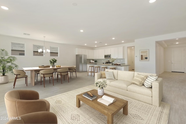 living room with an inviting chandelier, recessed lighting, light wood-style flooring, and visible vents