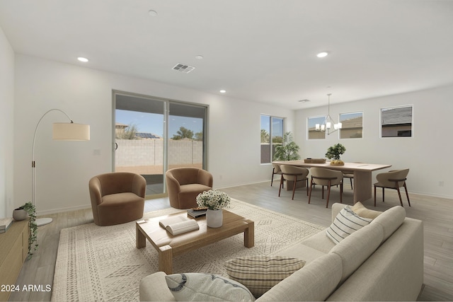 living area featuring a chandelier, baseboards, visible vents, and recessed lighting