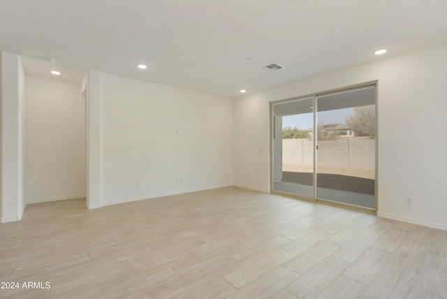 spare room with recessed lighting, light wood-type flooring, visible vents, and baseboards