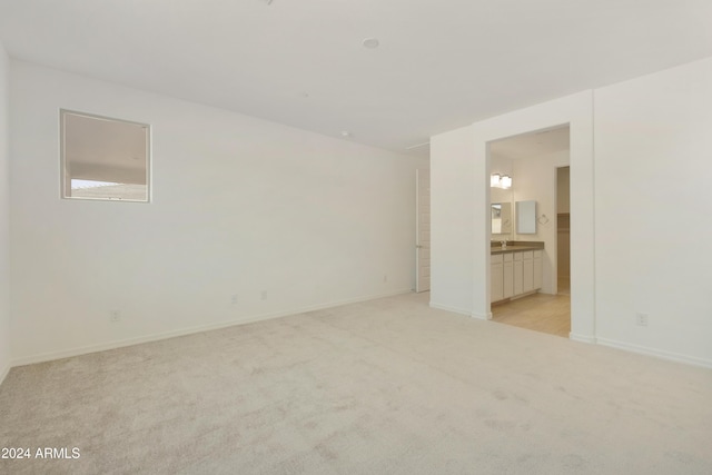 spare room with light colored carpet and baseboards