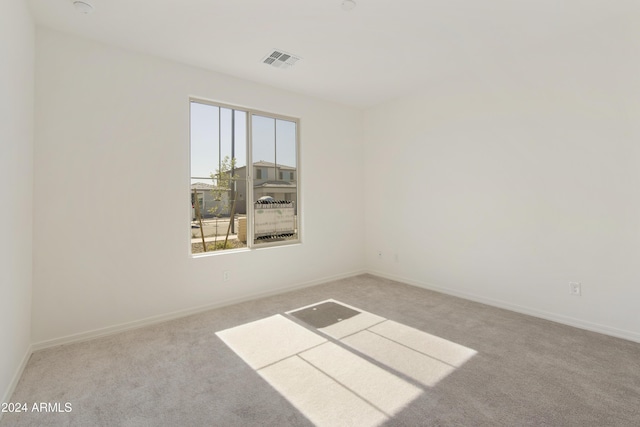 spare room featuring carpet flooring, baseboards, and visible vents