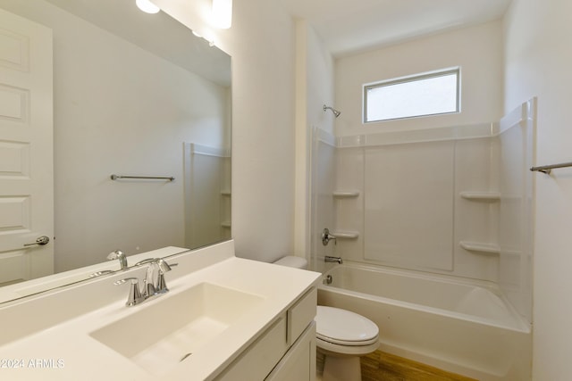 full bath featuring washtub / shower combination, vanity, toilet, and wood finished floors