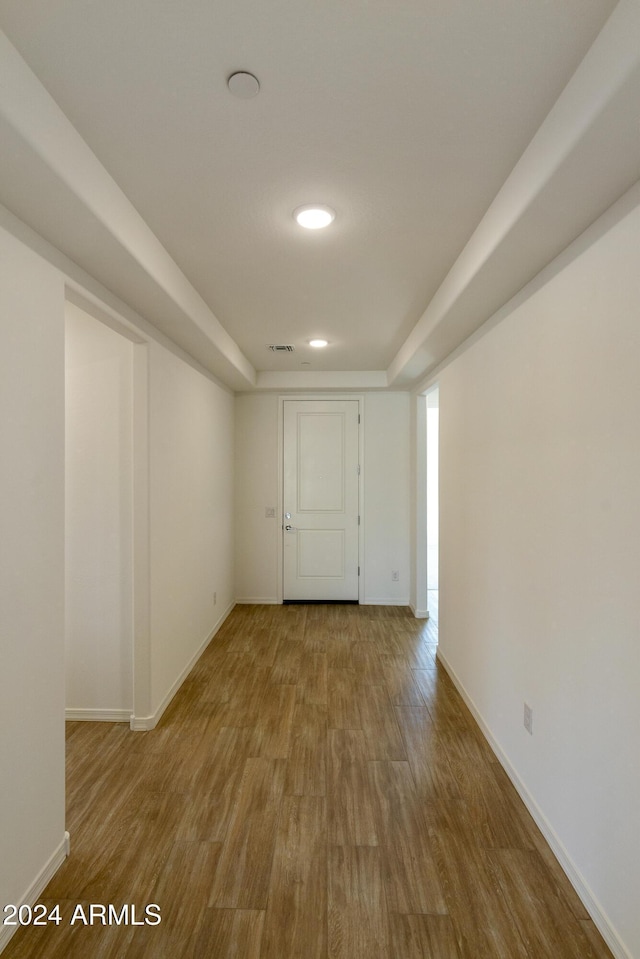 unfurnished room with visible vents, baseboards, and wood finished floors