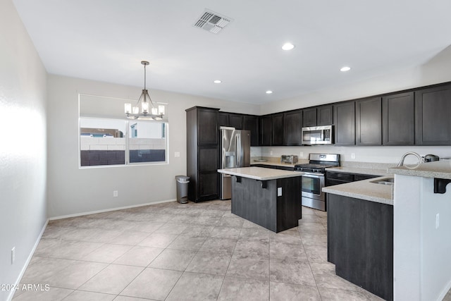 kitchen with appliances with stainless steel finishes, hanging light fixtures, a breakfast bar, sink, and a notable chandelier