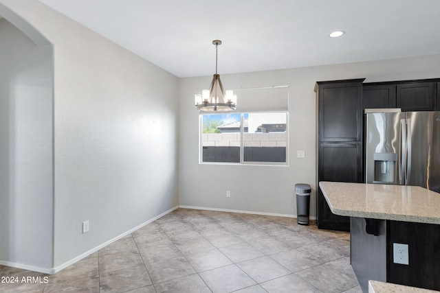 kitchen featuring decorative light fixtures, an inviting chandelier, a breakfast bar area, and stainless steel refrigerator with ice dispenser