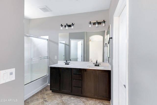 bathroom with enclosed tub / shower combo, ceiling fan, and vanity