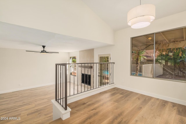 hallway with hardwood / wood-style flooring and vaulted ceiling