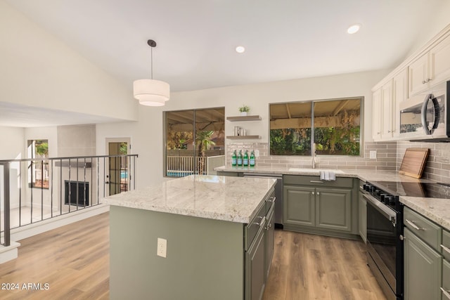 kitchen featuring backsplash, a healthy amount of sunlight, a kitchen island, and stainless steel appliances