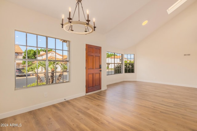 entryway featuring light hardwood / wood-style flooring, high vaulted ceiling, and an inviting chandelier