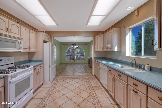 kitchen with decorative light fixtures, sink, a healthy amount of sunlight, and white appliances