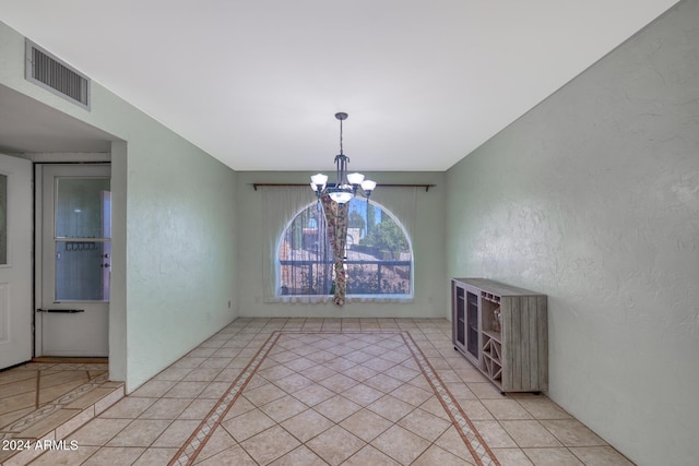 unfurnished dining area with a chandelier and light tile patterned floors