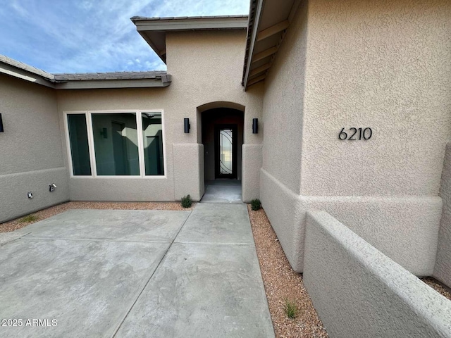 view of exterior entry featuring a patio area