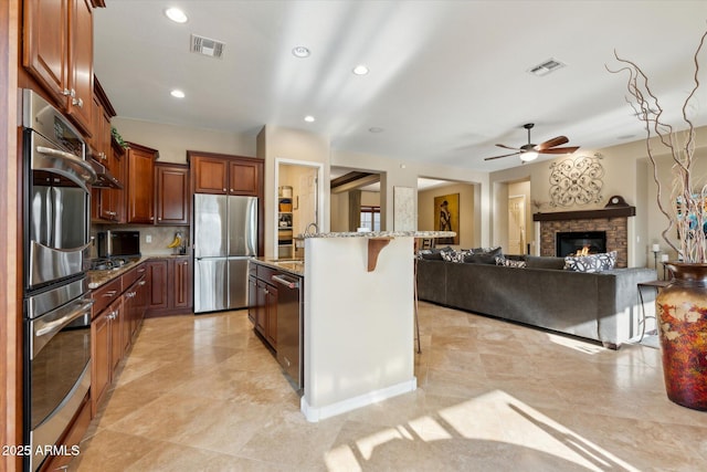 27308 N 56th Dr, Phoenix, AZ 85083 - kitchen featuring stainless steel appliances, a breakfast bar, light stone countertops, ceiling fan, and open floor plan