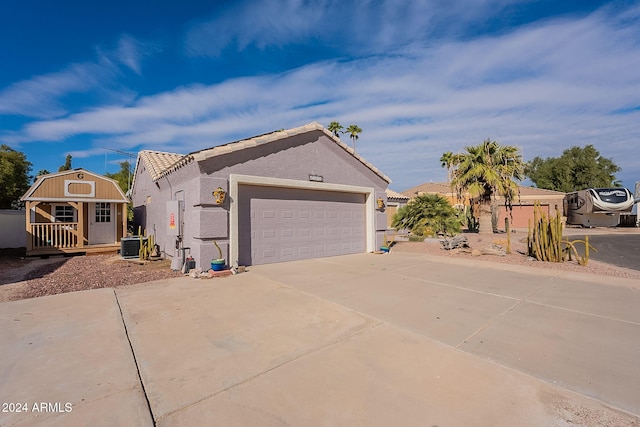 view of front of house with a garage and central AC