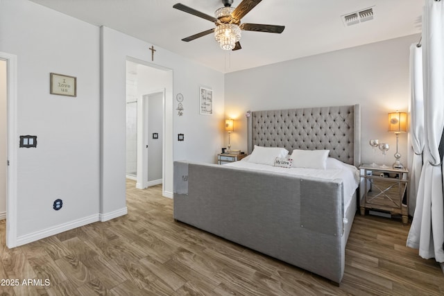 bedroom with ceiling fan, wood finished floors, visible vents, and baseboards