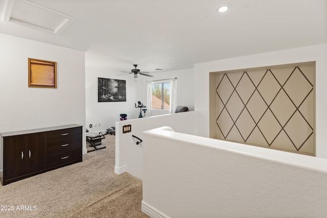 corridor featuring baseboards, an upstairs landing, attic access, and light colored carpet