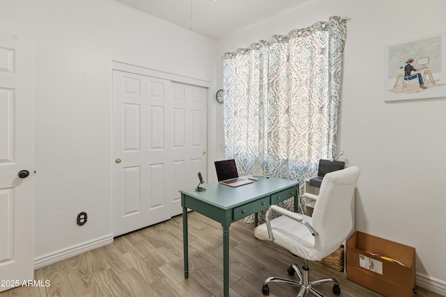 office space with baseboards and wood finished floors