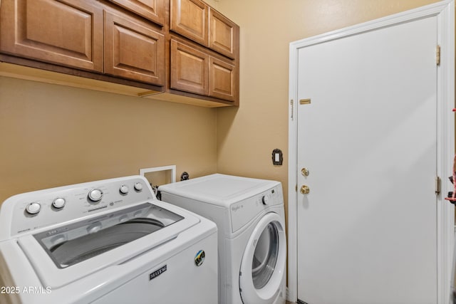 washroom featuring cabinet space and washer and clothes dryer