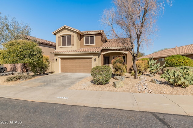 mediterranean / spanish home with concrete driveway, a tile roof, an attached garage, and stucco siding