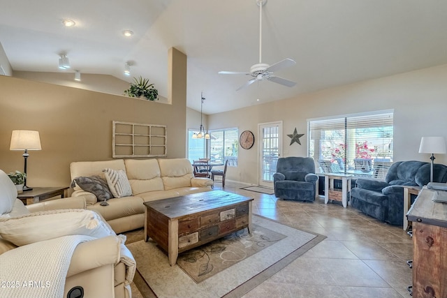 living room featuring ceiling fan, light tile patterned floors, and vaulted ceiling