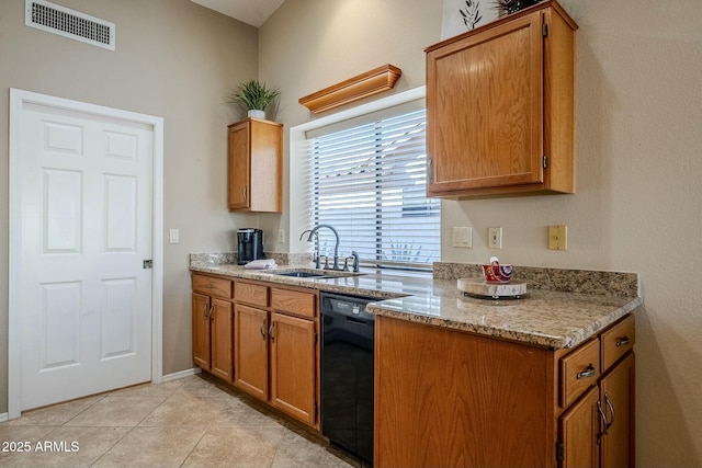 kitchen with dishwasher, light stone counters, light tile patterned floors, and sink