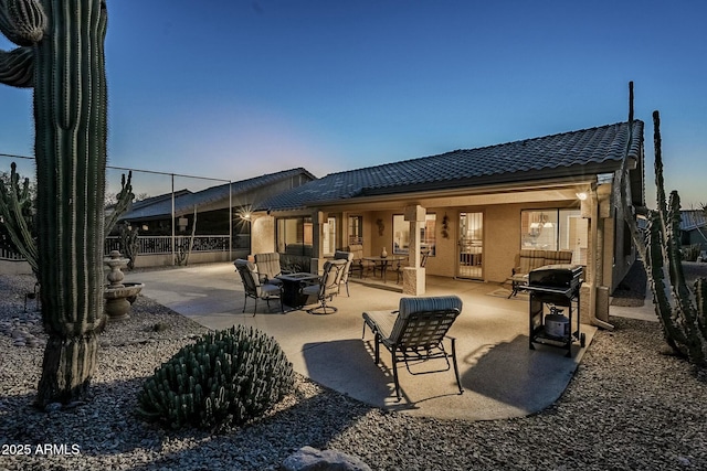 back of property featuring a patio area and a fire pit