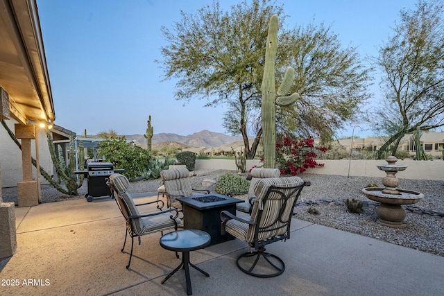 view of patio / terrace with a mountain view, a fire pit, and grilling area