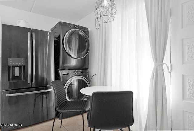 tiled dining area featuring stacked washer / dryer