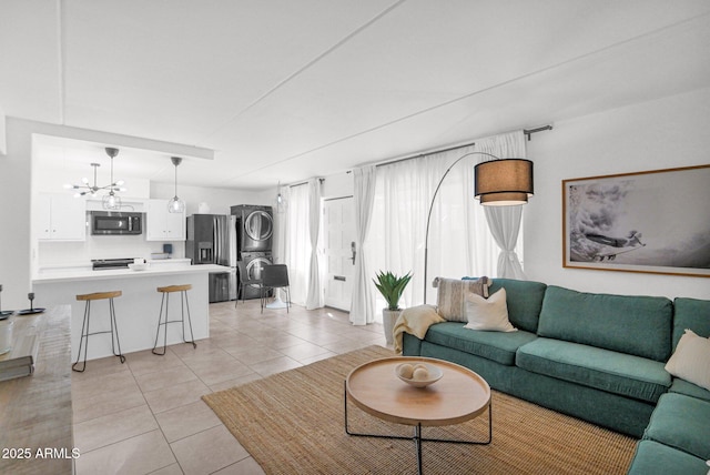 living area with an inviting chandelier, stacked washer / dryer, and light tile patterned floors