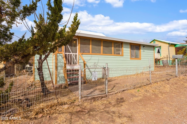 view of front of home featuring a sunroom and fence