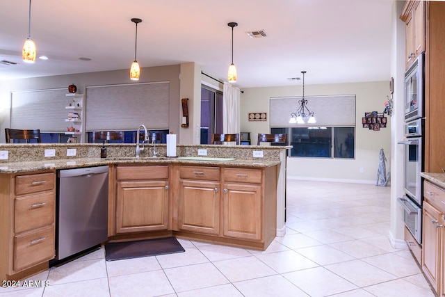 kitchen with pendant lighting, sink, stainless steel appliances, light stone countertops, and light tile patterned flooring