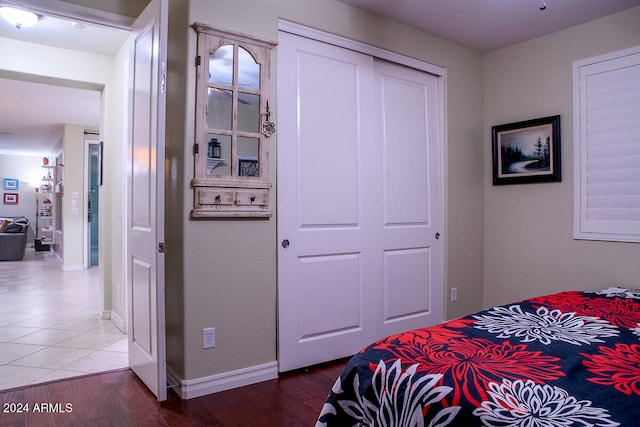 bedroom with dark wood-type flooring and a closet