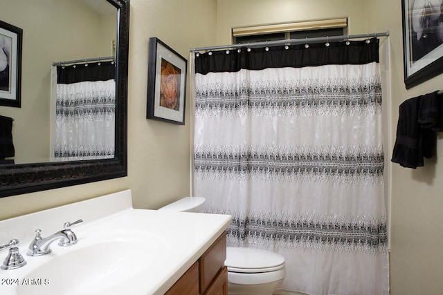 bathroom with vanity, curtained shower, and toilet