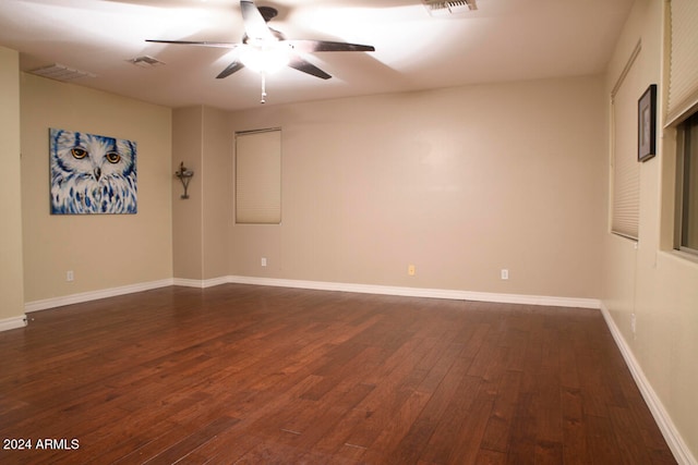 empty room featuring dark wood-type flooring and ceiling fan