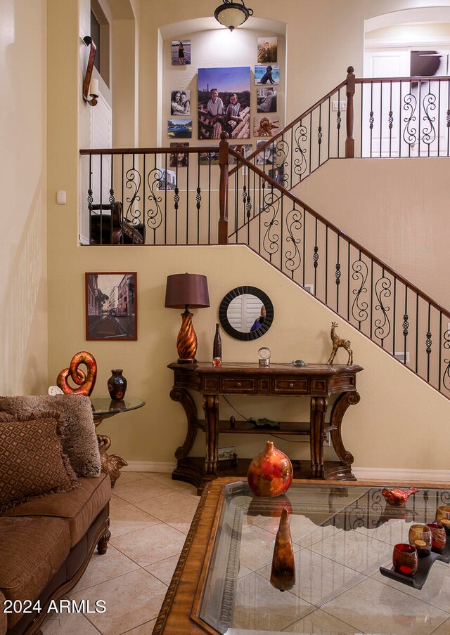 stairway with tile patterned flooring and a high ceiling