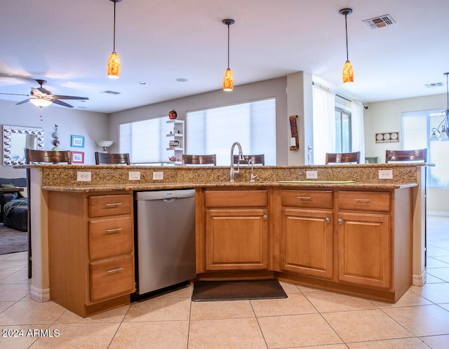 kitchen featuring sink, hanging light fixtures, stainless steel dishwasher, light tile patterned floors, and light stone counters